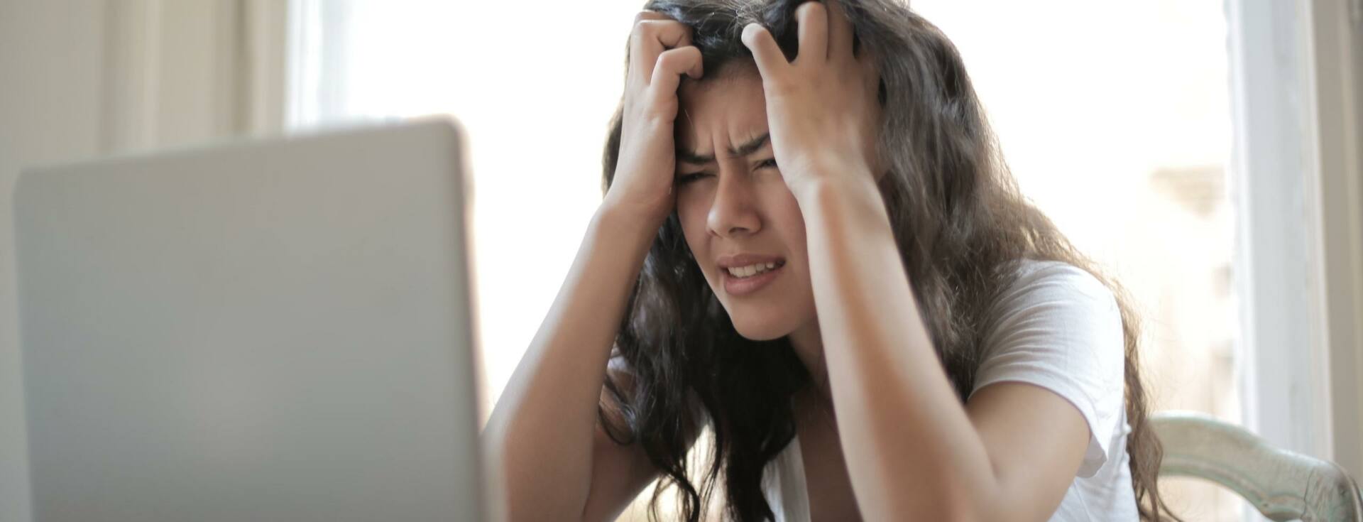 Frustrated woman looking at a computer and pulling hair