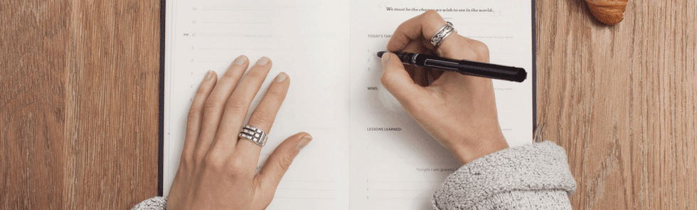 Woman writing new years resolutions in notebook