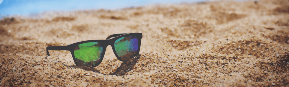 Sunglasses in sand on the beach