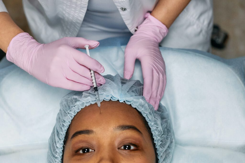 doctor injecting patient's forehead with a needle