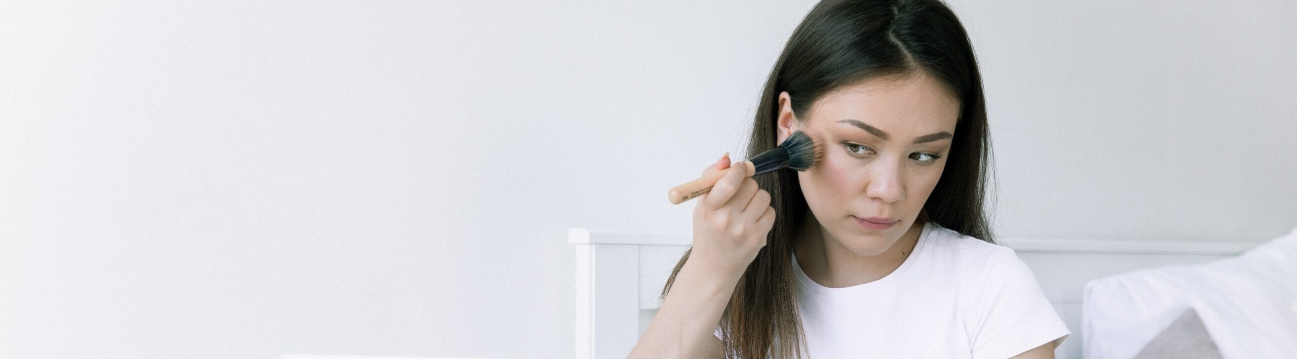 Woman applying makeup with a makeup brush