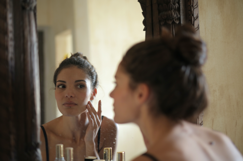 Woman examining skin in a mirror