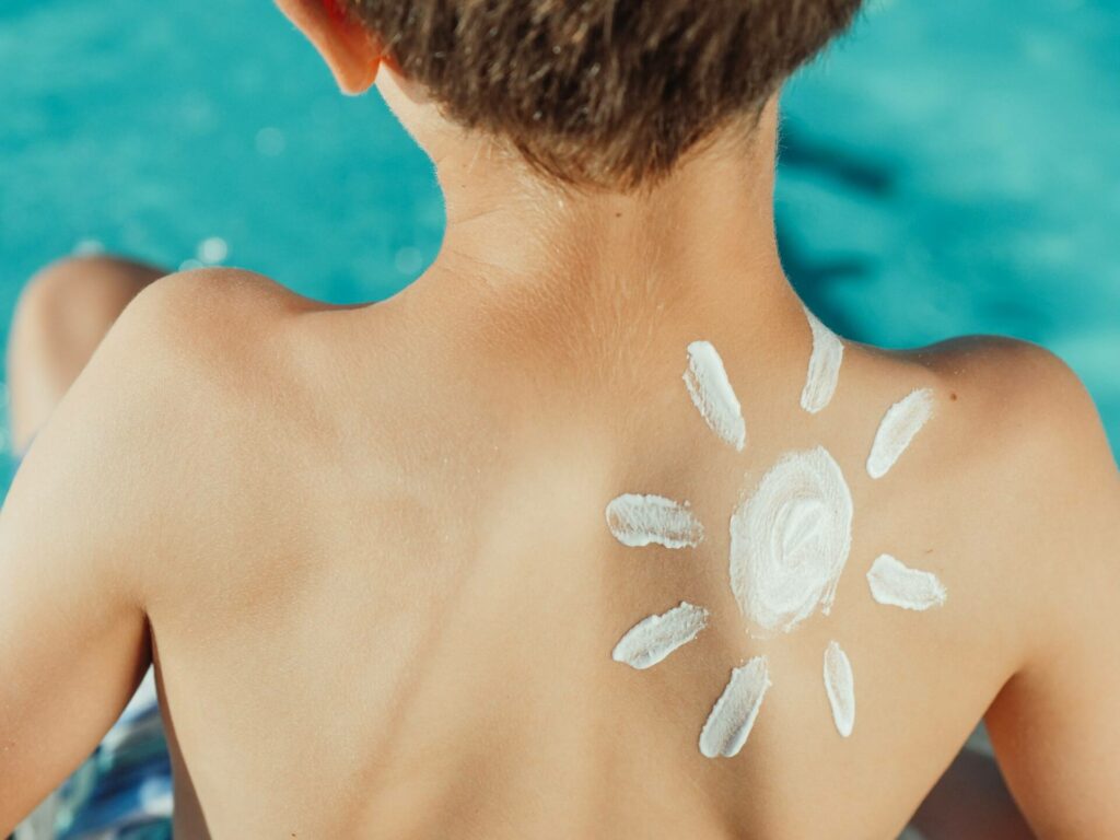 Sunscreen in the design of a sun on a little boys back