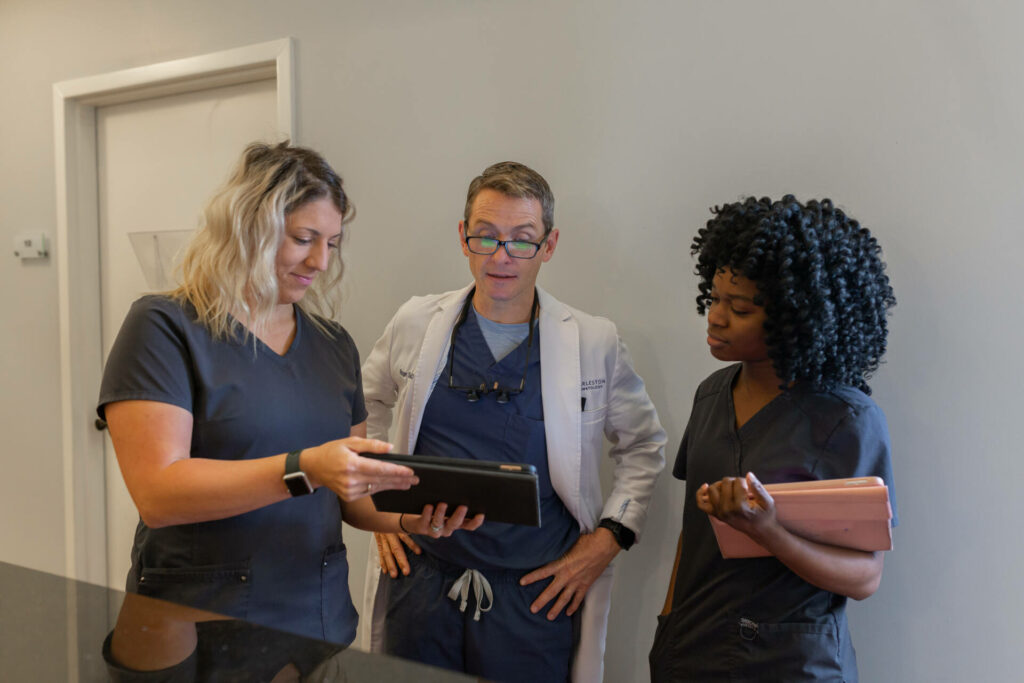 Dermatologist and two nurses looking at an iPad