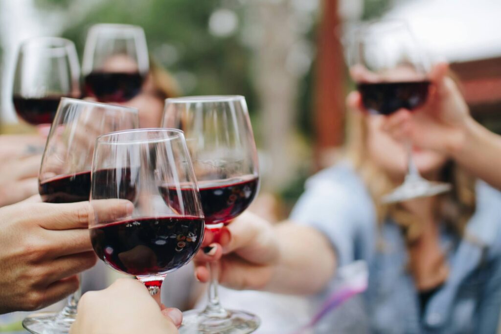 People cheering with red wine glasses
