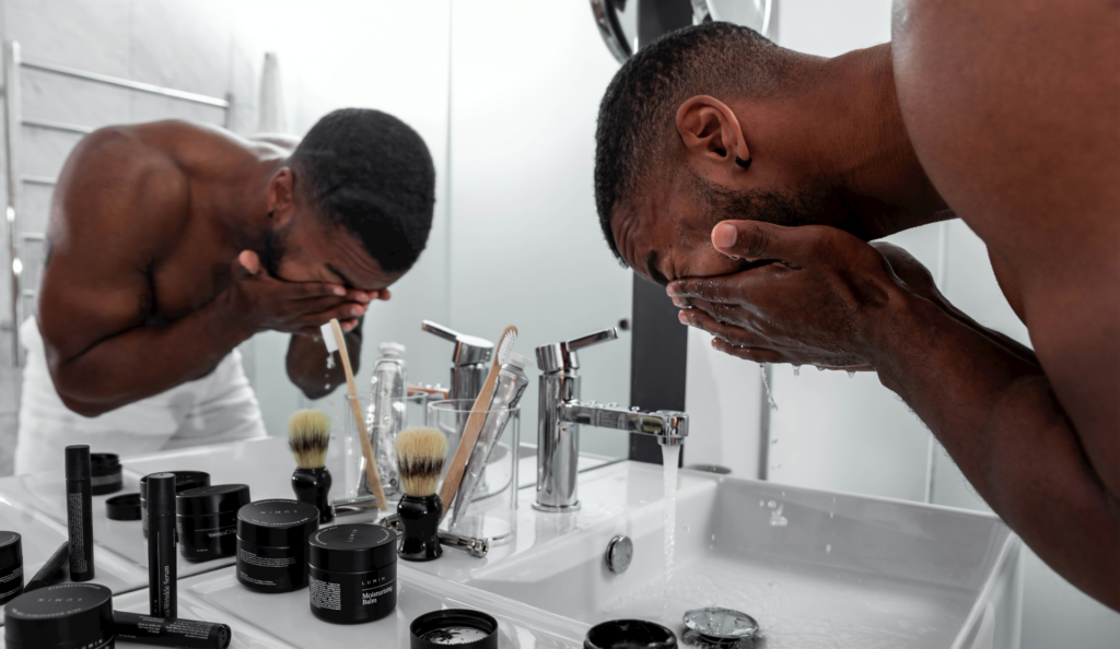 man washing face at sink