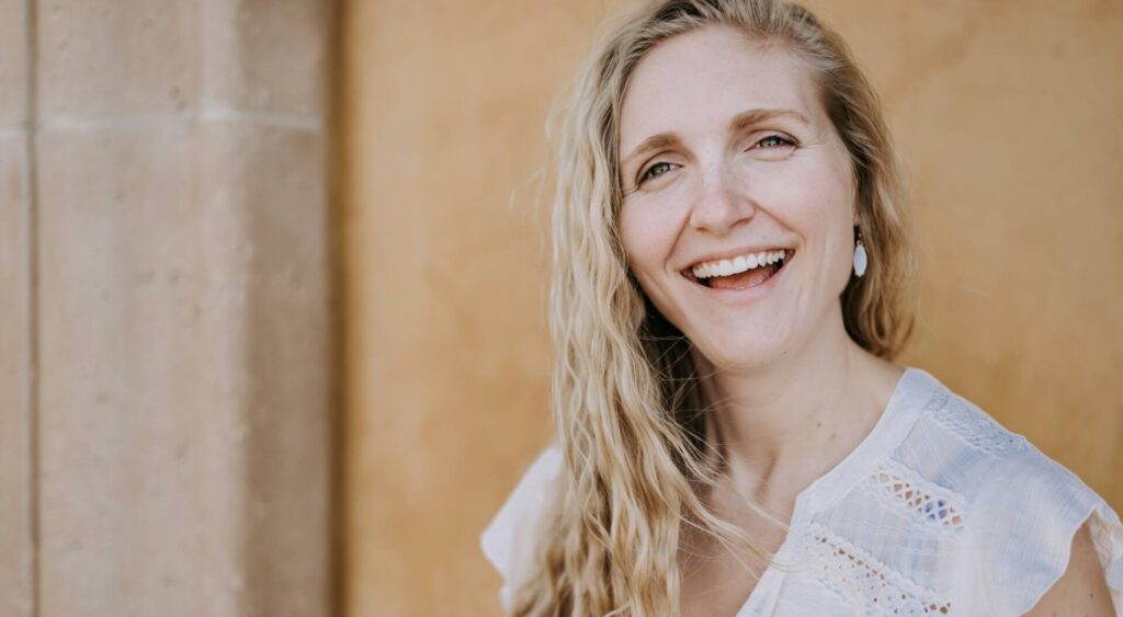 Blonde woman in white shirt smiling