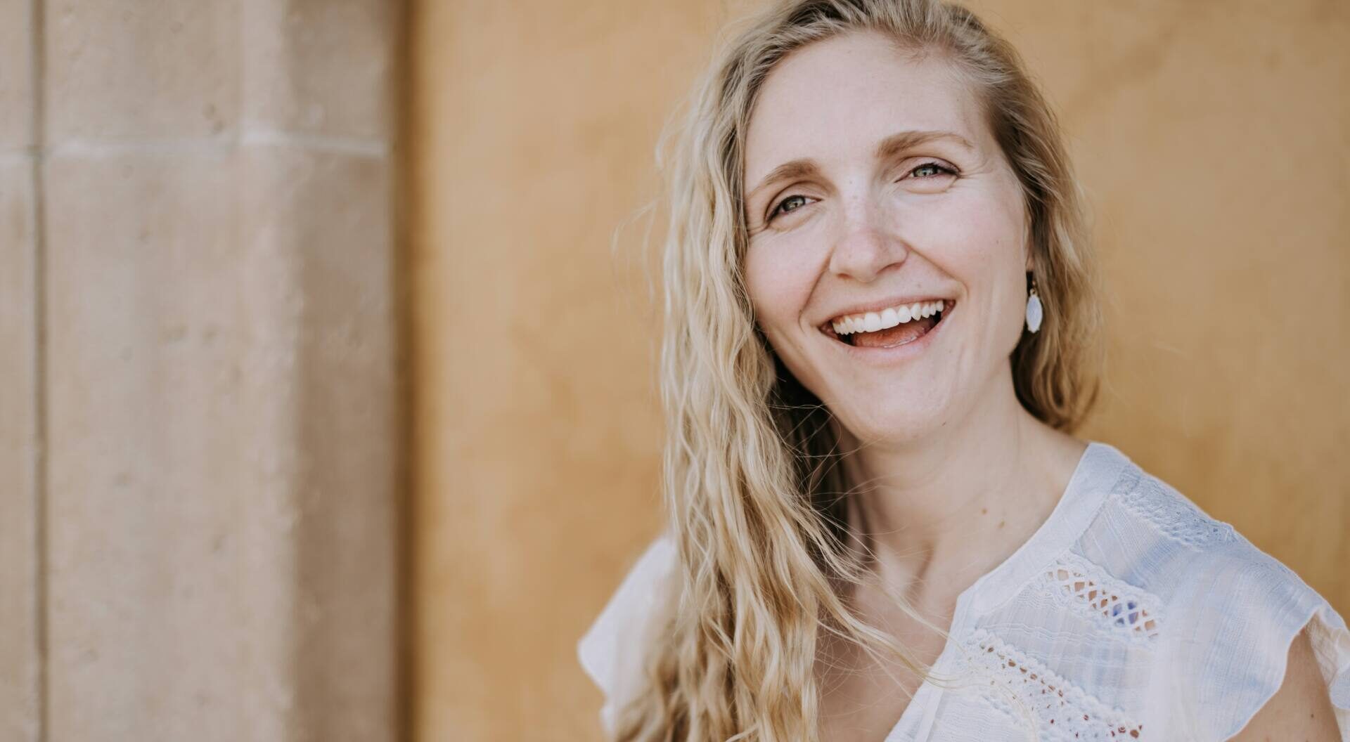 Blonde woman in white shirt smiling