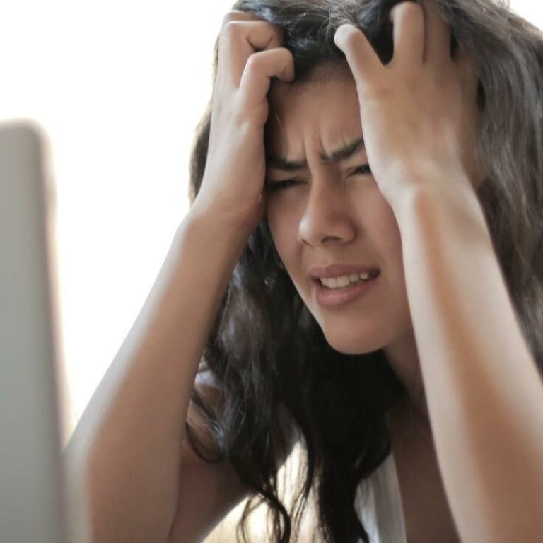 Frustrated woman looking at a computer and pulling hair