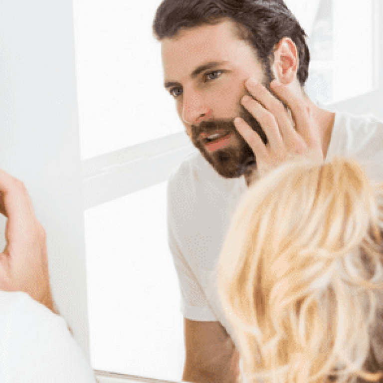 Woman and man looking at their skin in a mirror