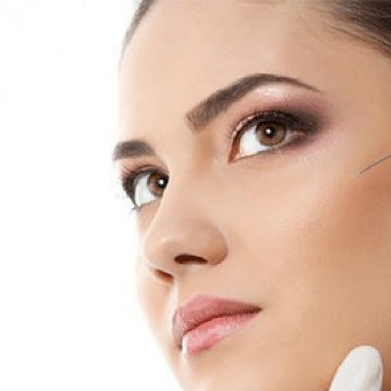 Doctor injecting needle into woman's cheek
