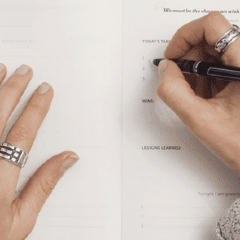 Woman writing new years resolutions in notebook