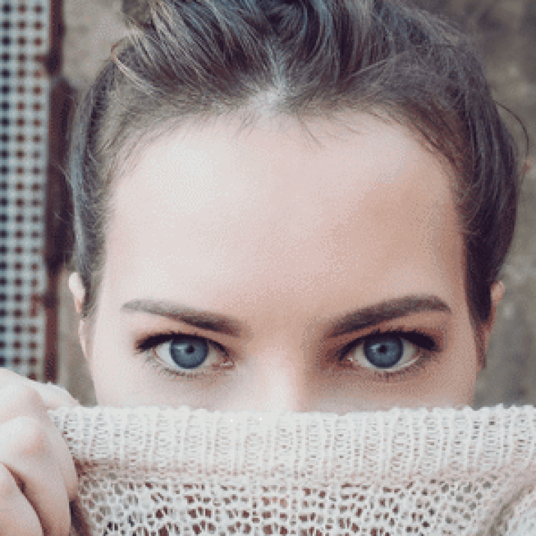Woman hiding mouth by pulling her sweater up