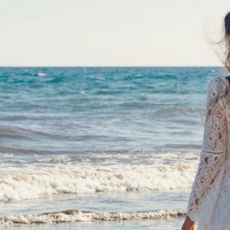 Woman walking towards the ocean on the beach