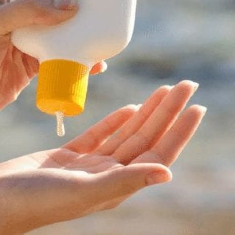 Person squeezing sunscreen on their hands