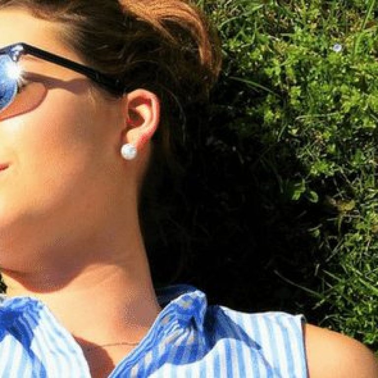 Woman wearing sunglasses laying in grass