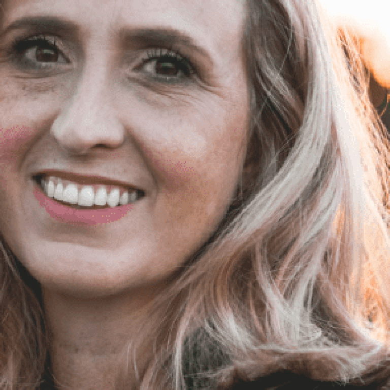 Woman outside in a field smiling