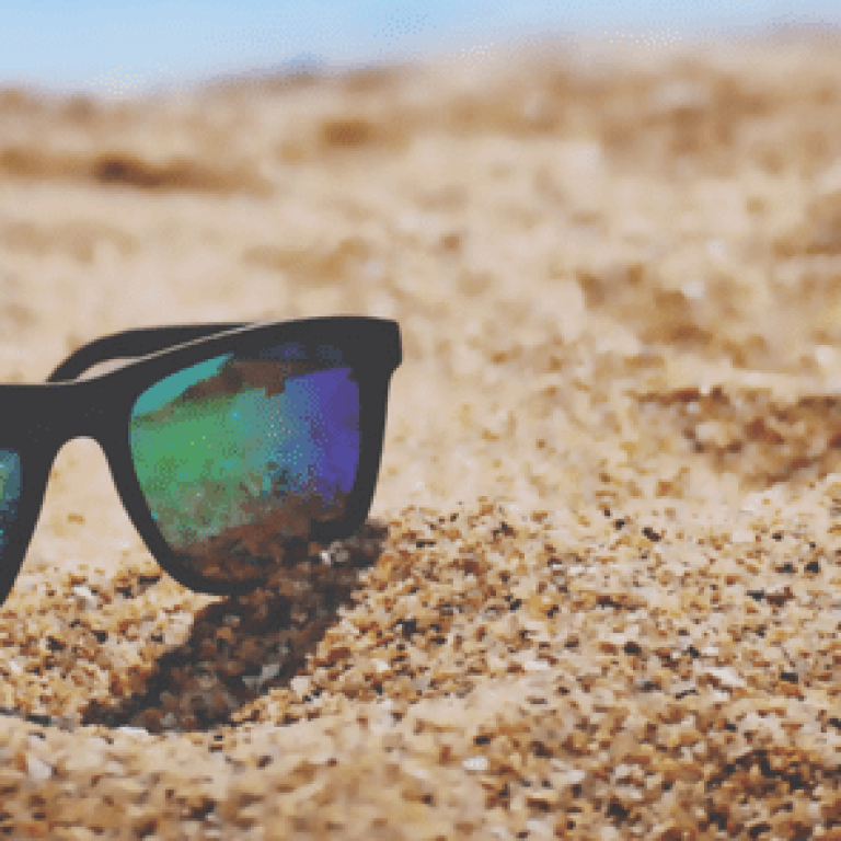 Sunglasses in sand on the beach