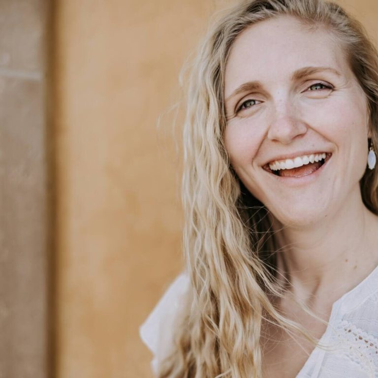 Blonde woman in white shirt smiling