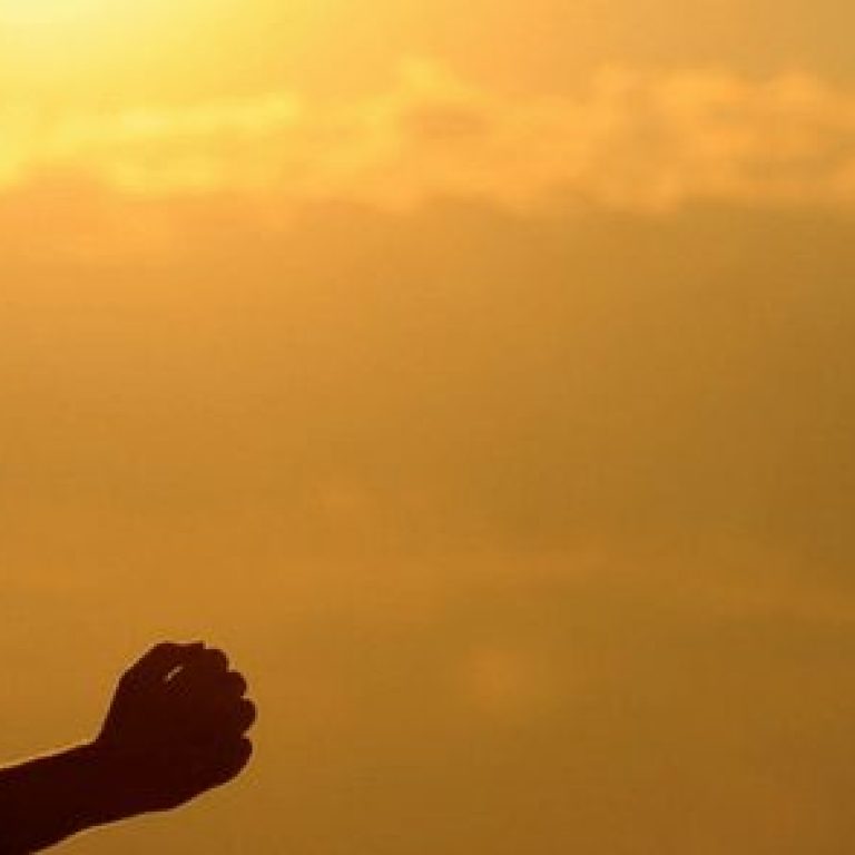 Woman wearing a visor and running at sunset