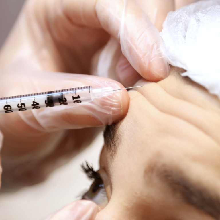 Doctor injecting botox into patient's forehead