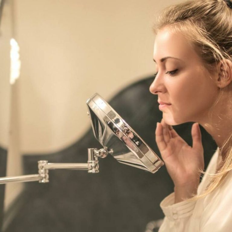 Woman examining face in a mirror