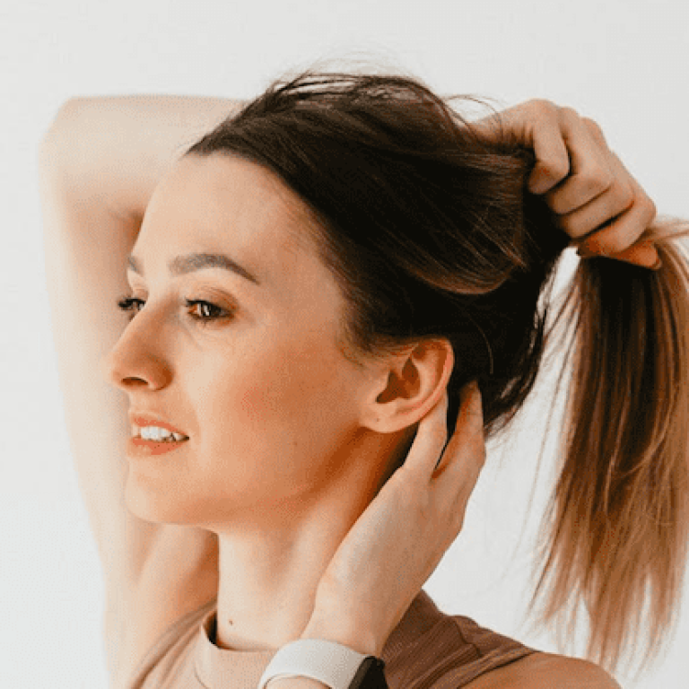 Woman pulling her hair back into a ponytail