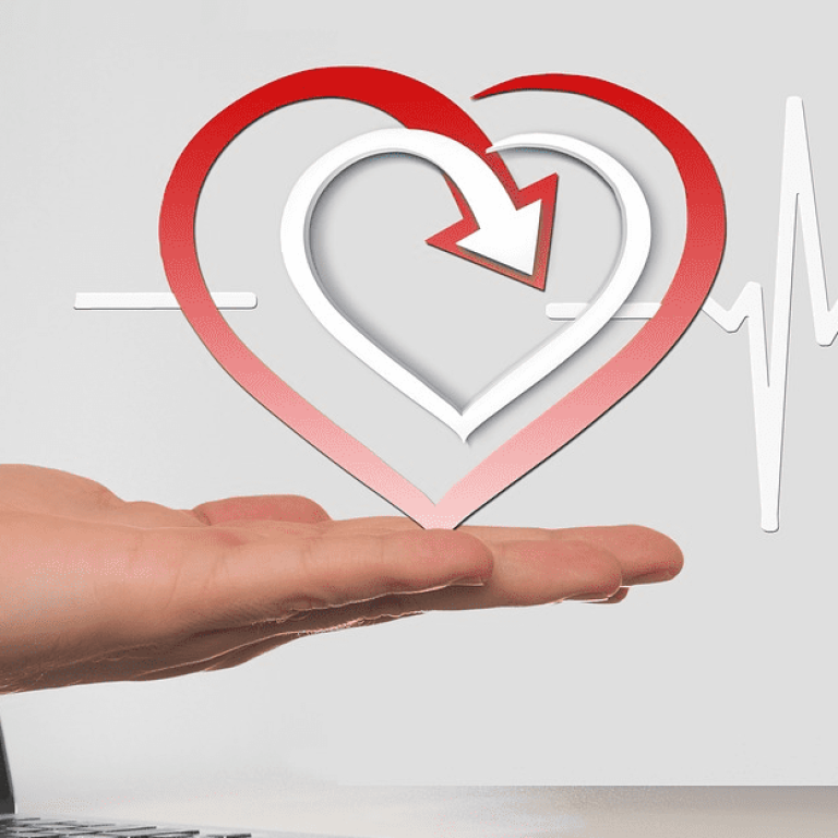Hand coming out of a computer screen holding a heart