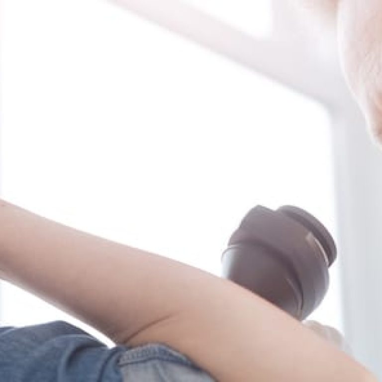 Doctor examining patient's arm with magnifying glass