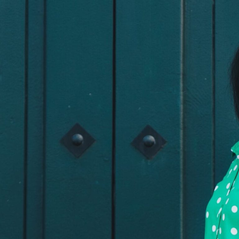 Woman of color standing in front of a door