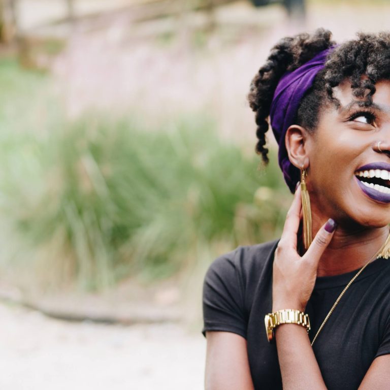Woman smiling with her hand to her face.