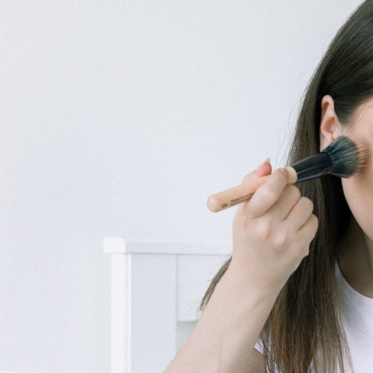 Woman applying makeup with a makeup brush