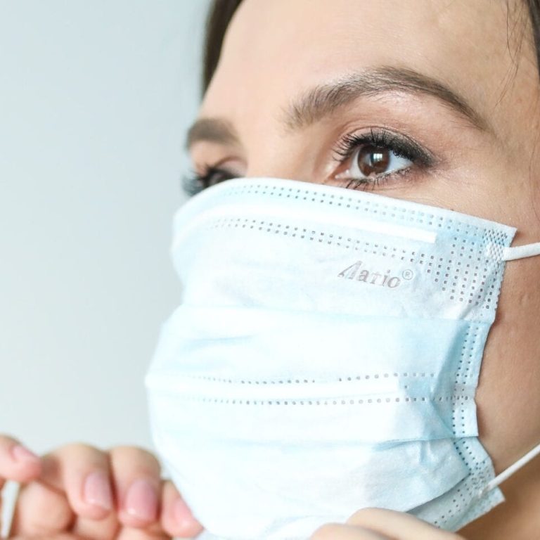 Woman adjusting the mask on her face