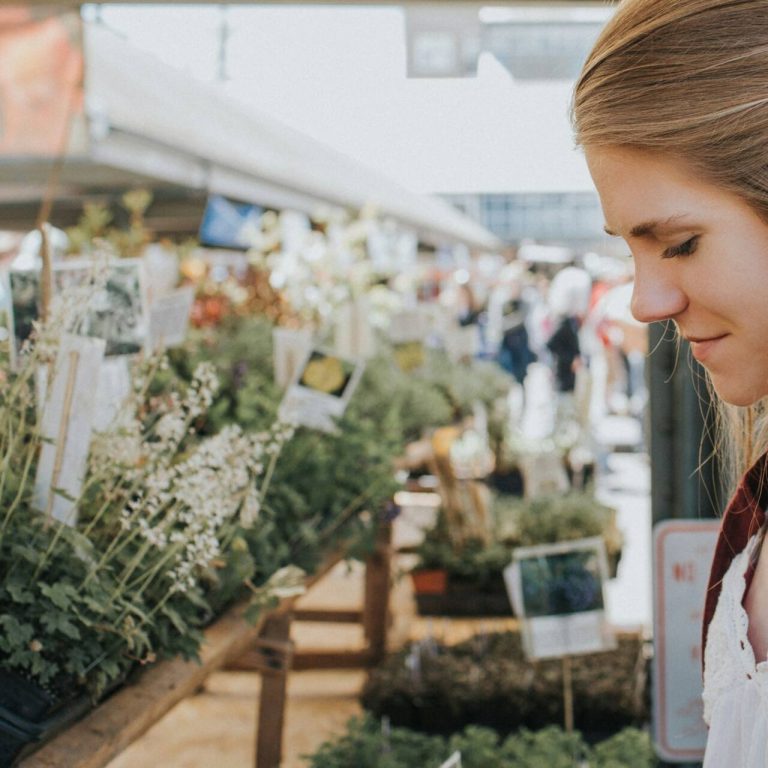 Woman at the farmers market looking at plants